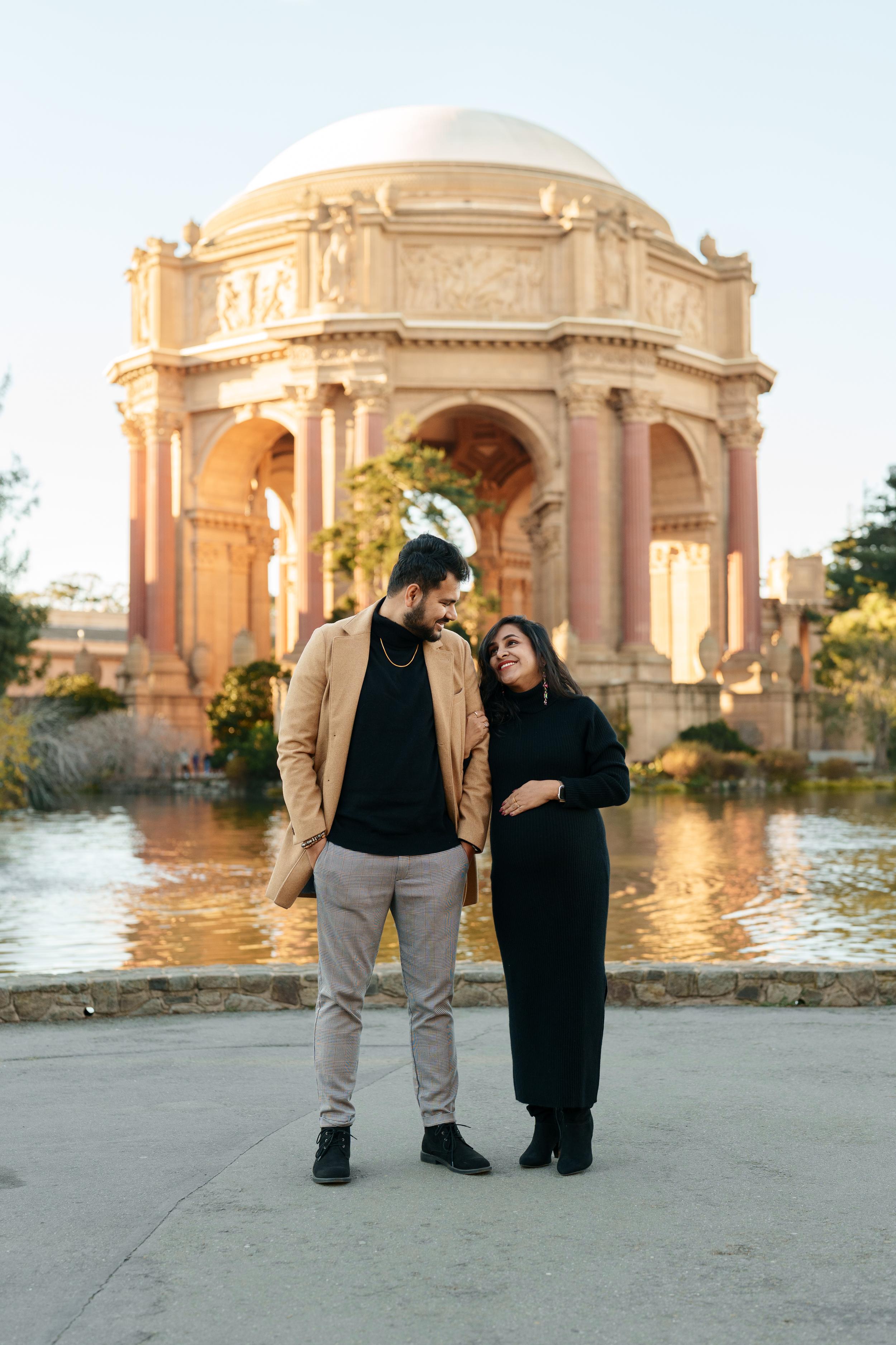 Bay Area couples portrait of a smiling pair in camel blazer and black knit dress at San Francisco's Palace of Fine Arts